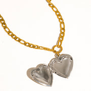 Gold chain necklace with two heart-shaped pendants on a white background
